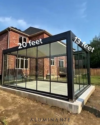 Freestanding louvered pergola with frameless glass walls
