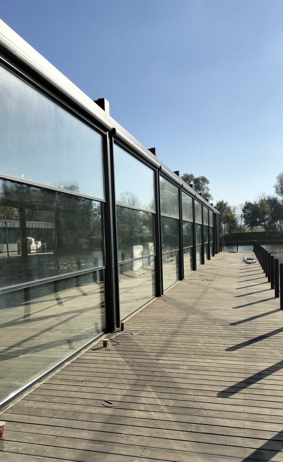 Row of tall glass panels along the deck of a lakeside restaurant