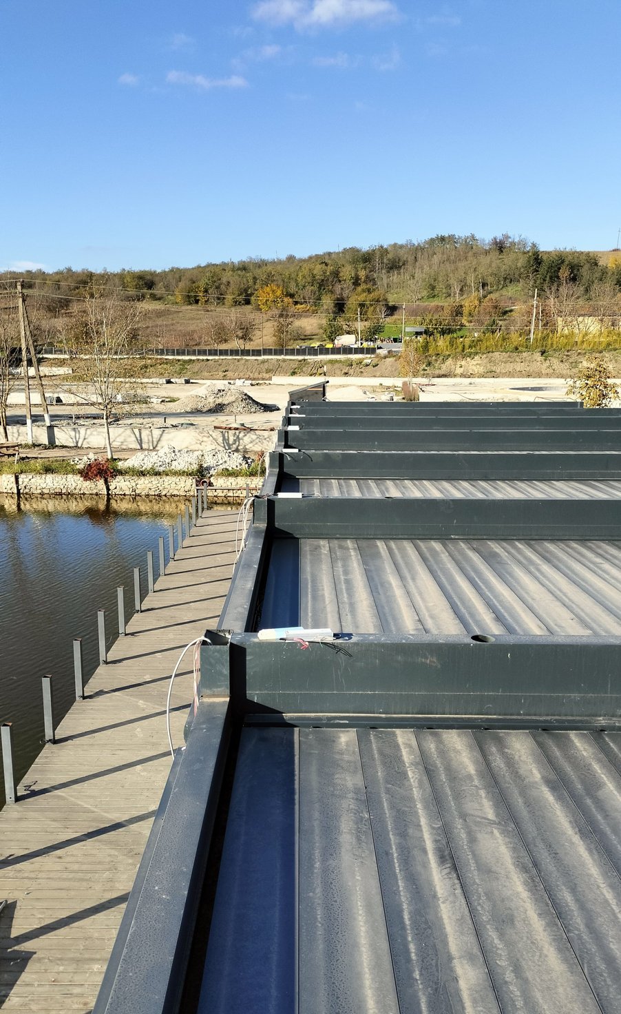 Louvered pergola roof seen from above with the lake and hills behind