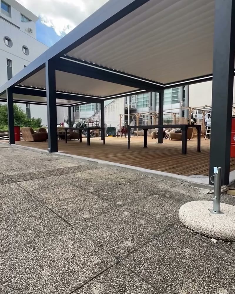Louvered pergola modules over a rooftop deck with tables