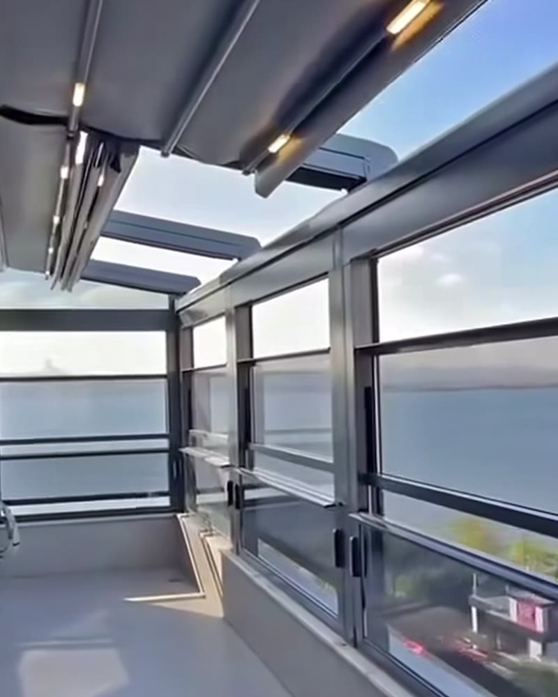 Balcony with a retractable fabric roof and guillotine glass overlooking the sea