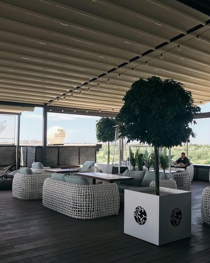 Retractable fabric roof over a hotel rooftop terrace with lounge seating