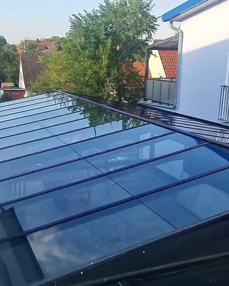 Gable glass roof on aluminum profiles next to a house