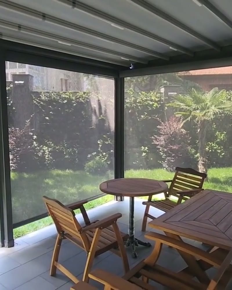 Pergola with zip screens lowered around a garden seating area