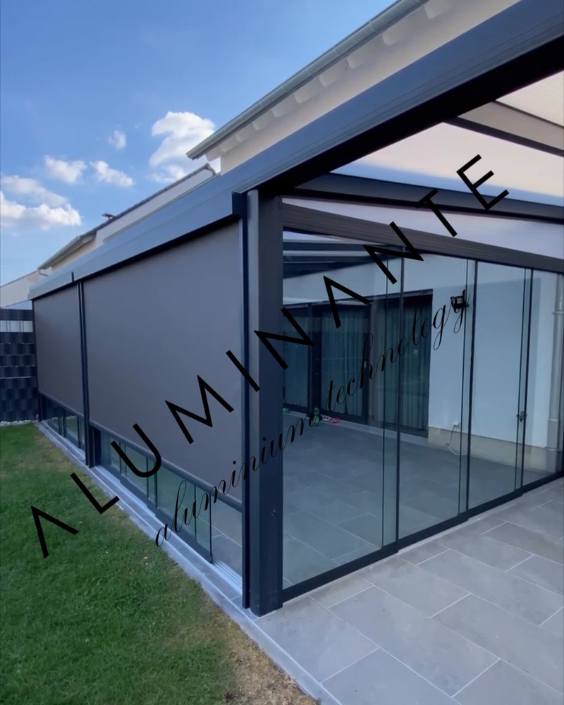 Glass roof terrace by a house with zip screens lowered and sliding glass on the side