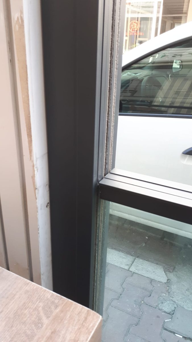 Close-up of a dark aluminum frame holding a glass panel