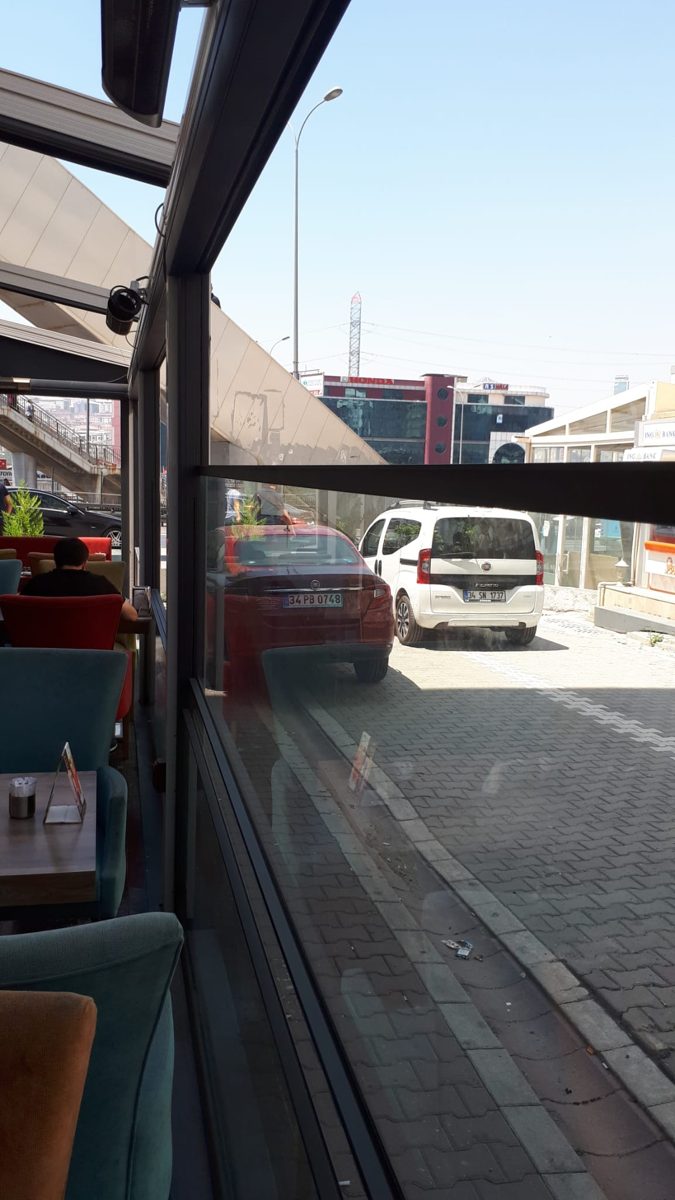 View from inside the glazed restaurant terrace onto the street